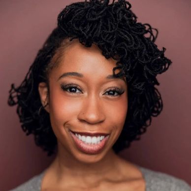 Smiling woman with styled curly hair and warm eyes.