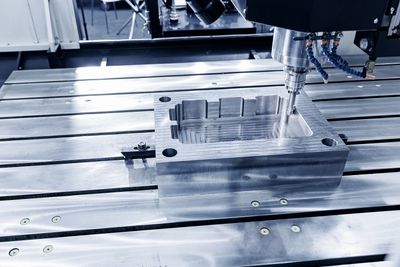 CNC milling machine processing a metal mold.