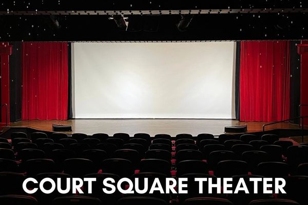 Empty Court Square Theater with red curtains and a blank screen.
