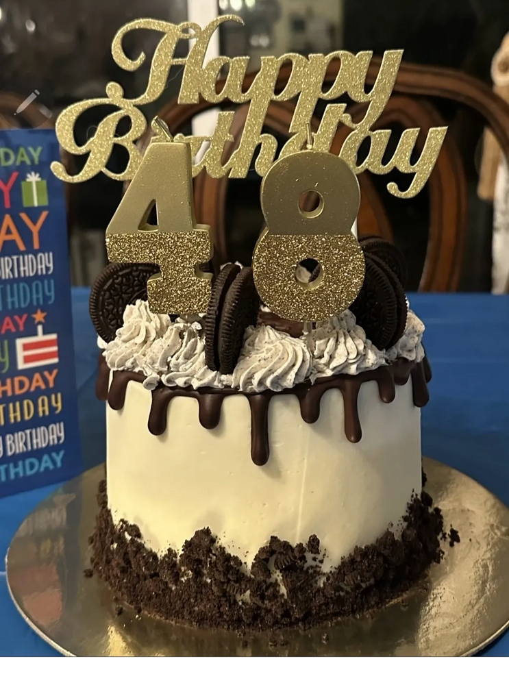 Elegant 48th birthday cake with gold glitter toppers and Oreo decorations.