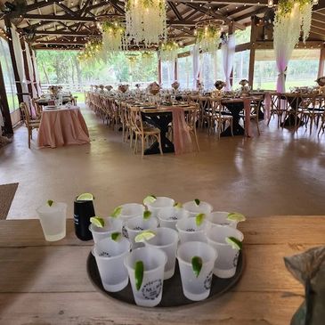 Rustic event space with hanging floral chandeliers and arranged tables.