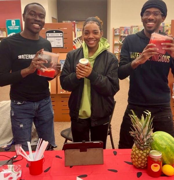 Three black people holding natural watermelon juice cold pressed lemonade juice at pop-up baltimore