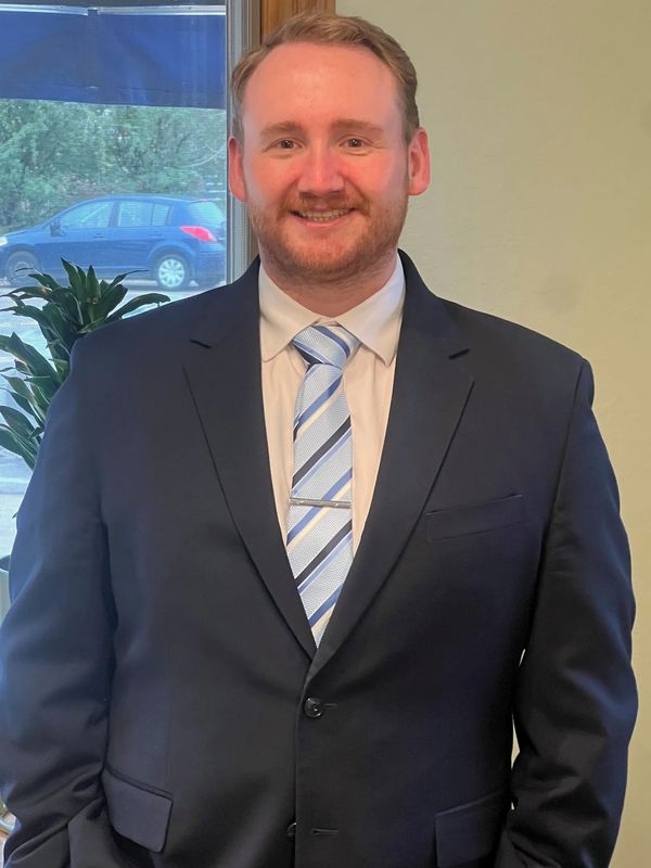 Man in suit smiling indoors.
