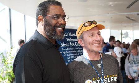 NFL Hall of Fame "Mean" Joe Greene taking a picture with guest at past Super Bowl party