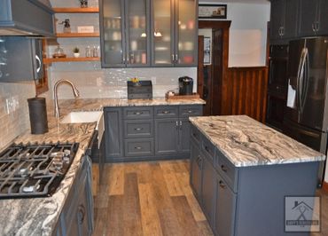 Full kitchen remodel with custom cabinets, island, built in range, countertops, and vinyl plank