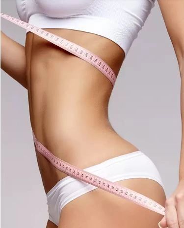 Slim women measuring waist