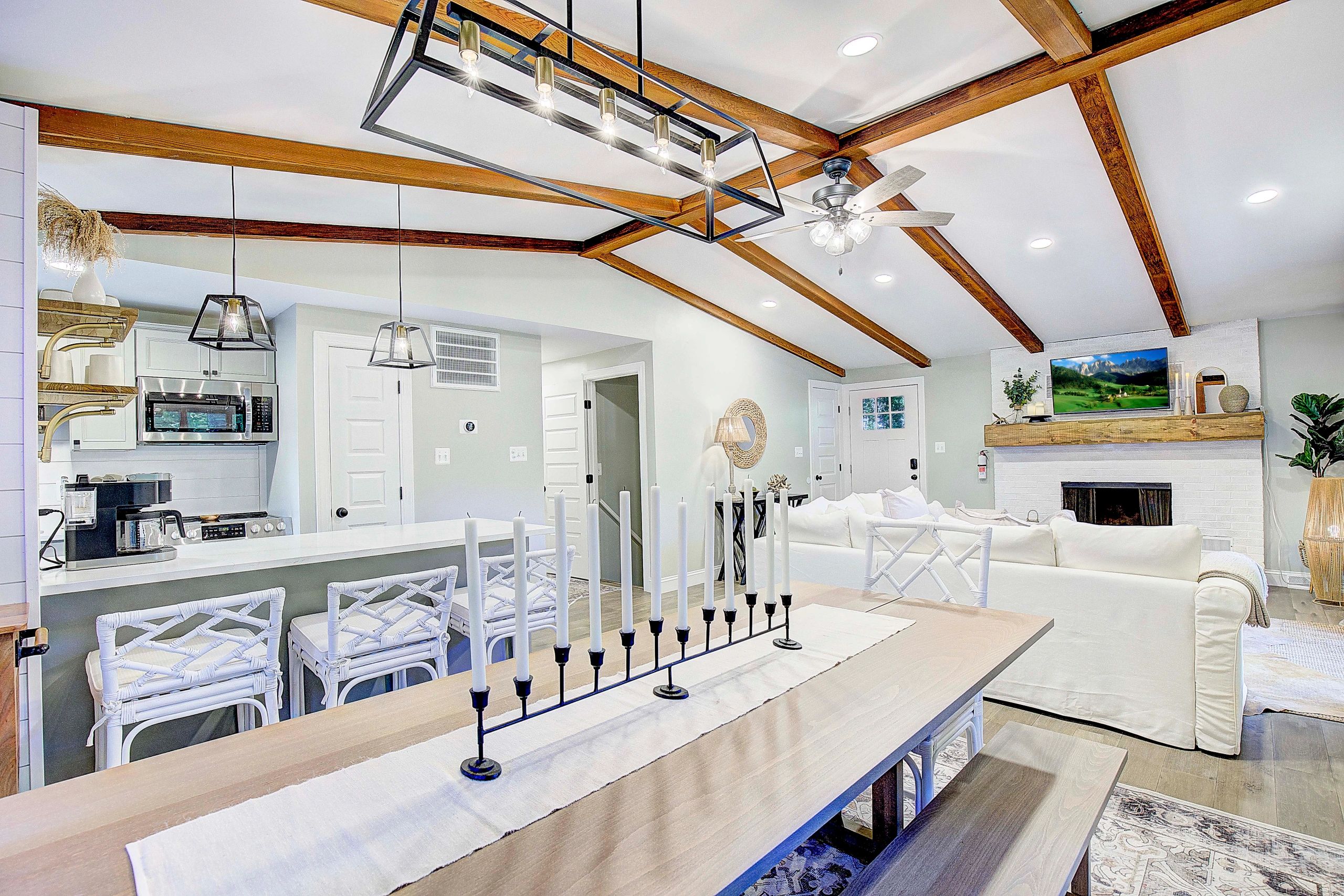 Bright living room and kitchen with wooden beams.