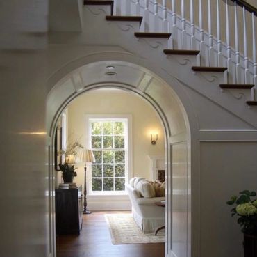 Arched entry with moldings into a comfortable, warm living room