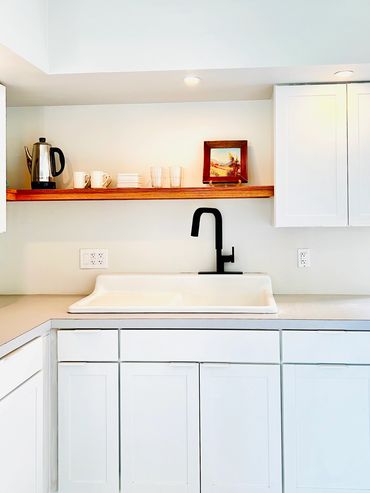Minimalistic design kitchen with farm sink, open shelving, white shaker cabinets