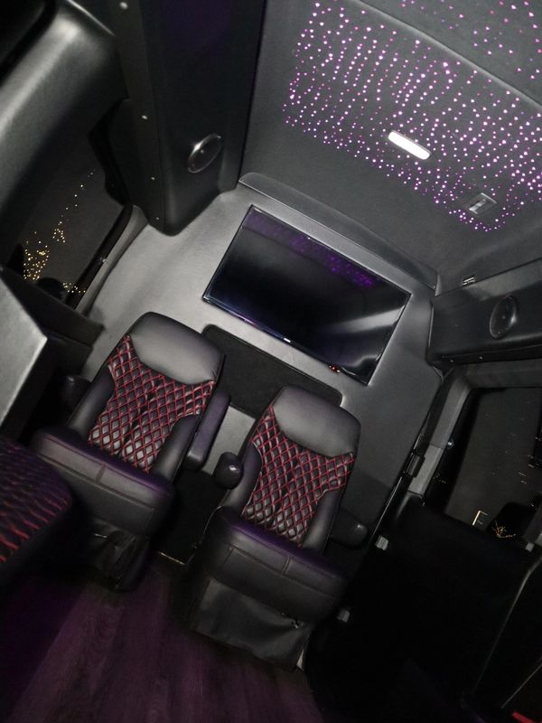 Luxurious black leather seats with red stitching inside a sleek vehicle.