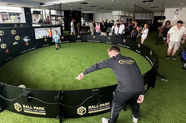 Indoor football tech arena with kids playing and adults watching.