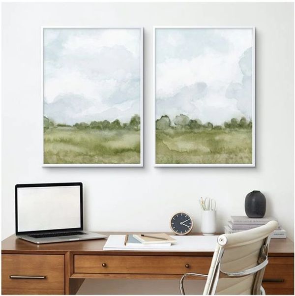 Two impressionistic green watercolour landscapes hang framed over a desk by Renée Anne