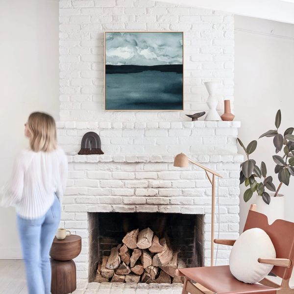 Indigo landscape painting by Renée Anne Bouffard-McManus hangs over a fireplace.