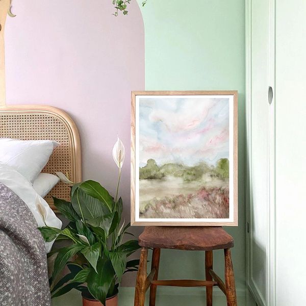 Watercolour landscape with a tree line and pink sky by Renée Anne Bouffard-McManus in a bedroom.