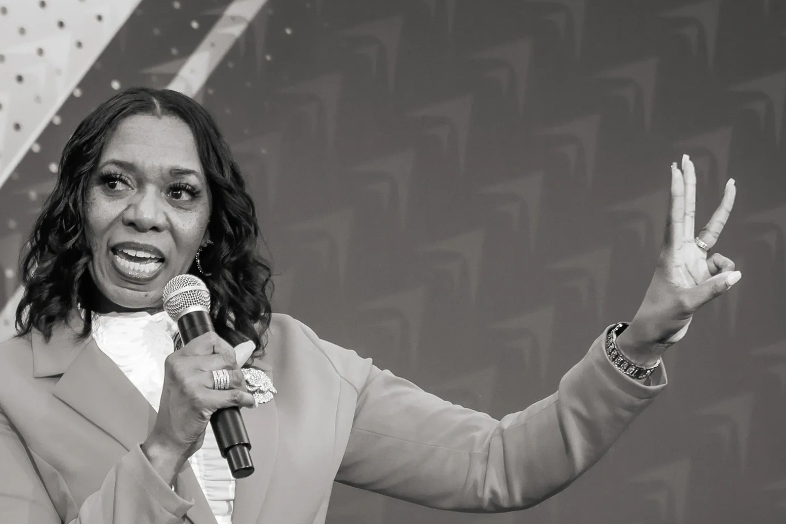Woman speaking with microphone and gestures.