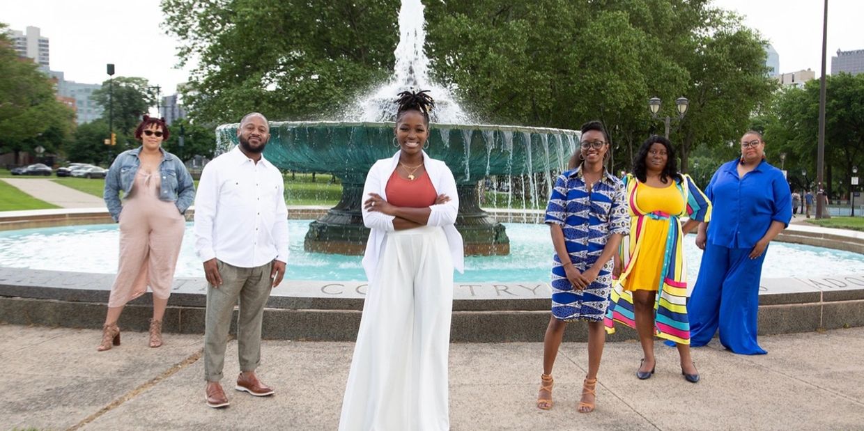 black psychotherapists standing in front of a fountain. 