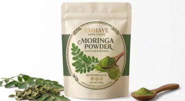 Package of Emhaye Moringa Powder with fresh leaves and powder on a wooden spoon.