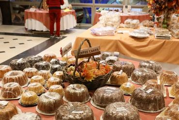 Table filled with wrapped coffee cakes on display at an event.