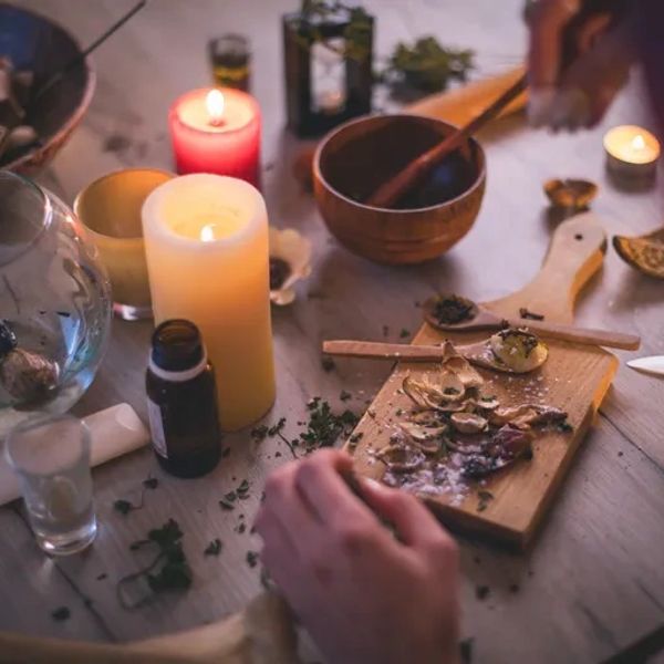 Person preparing herbs by candlelight.