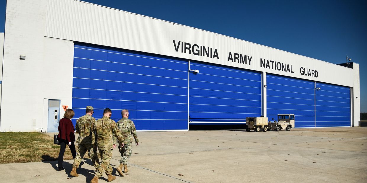 Group of military personnel walking towards Virginia Army National Guard building.