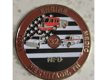 Badge featuring fire engine, ambulance, and police car with American flag background.