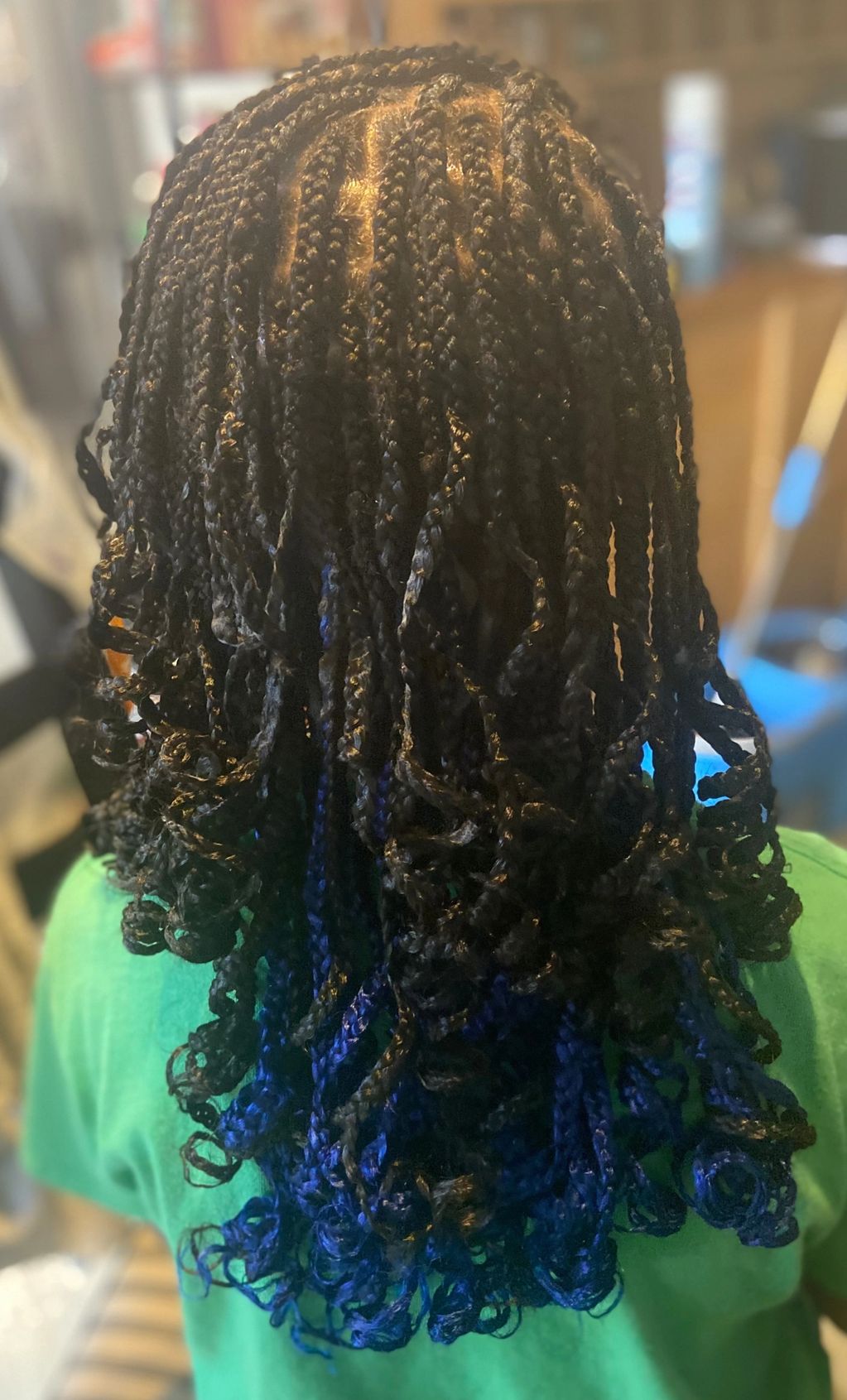 Medium box braids with added hair and curls.