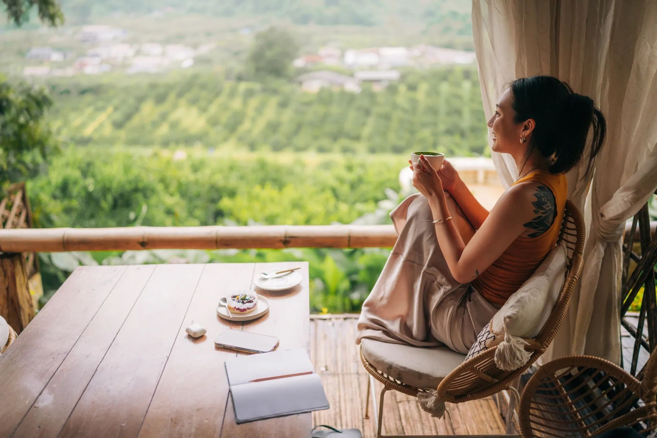 Woman enjoying tea with a scenic view.