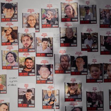 Wall covered with posters of missing people saying "Bring Him/Her Home Now!"