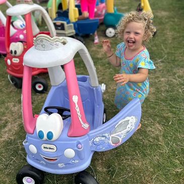 small girl smiling with cozy coupe