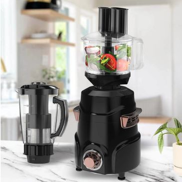 Black food processor with fresh vegetables inside on kitchen counter.