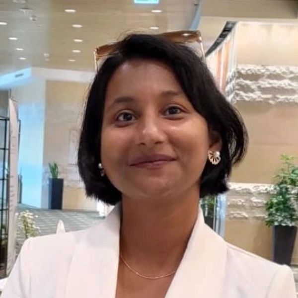 Smiling woman with short hair indoors.