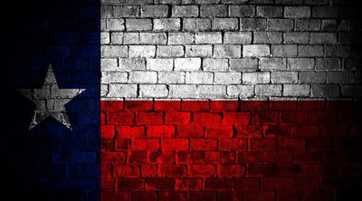 Texas state flag painted on a brick wall.