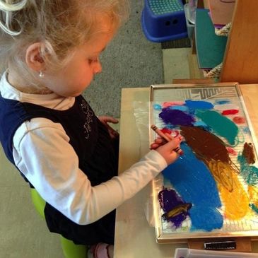 A littal girl making drawing with multipal colours
