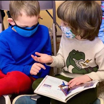 Two kids wearing mask and doing study