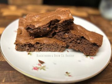 Two pieces of homemade chocolate brownies on a floral plate.