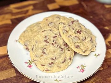 Plate of freshly baked chocolate chip cookies on a floral plate.