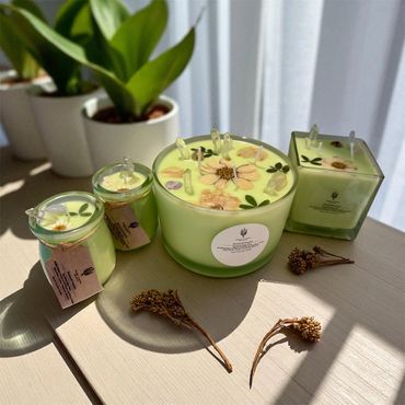 Orchard Freesia candles in various jars, adorned with dried flowers and clear quartz points.