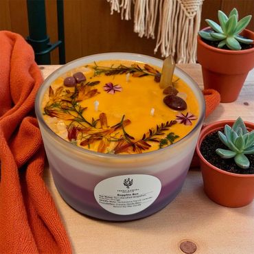Sapphic Sun candle adorned with botanicals and crystals.