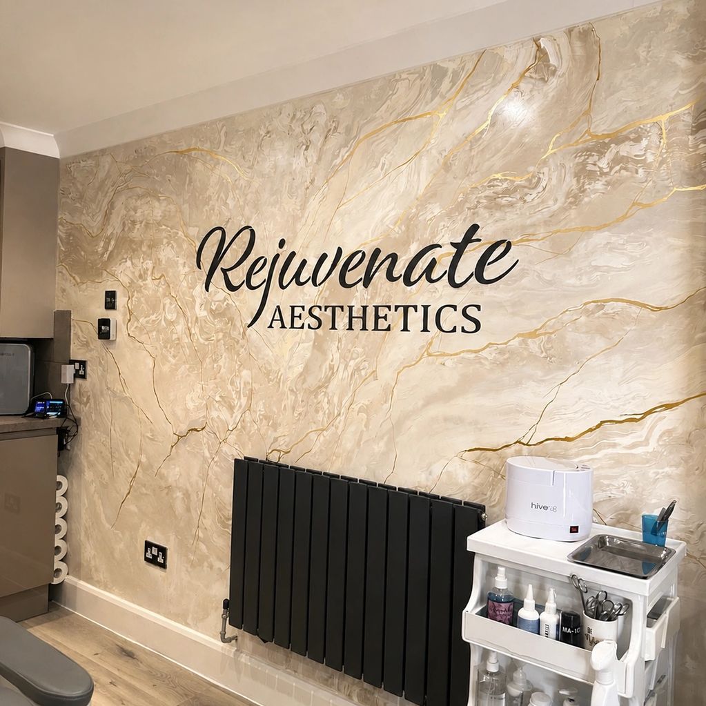 Wall with 'Rejuvenate Aesthetics' logo in a modern clinic.