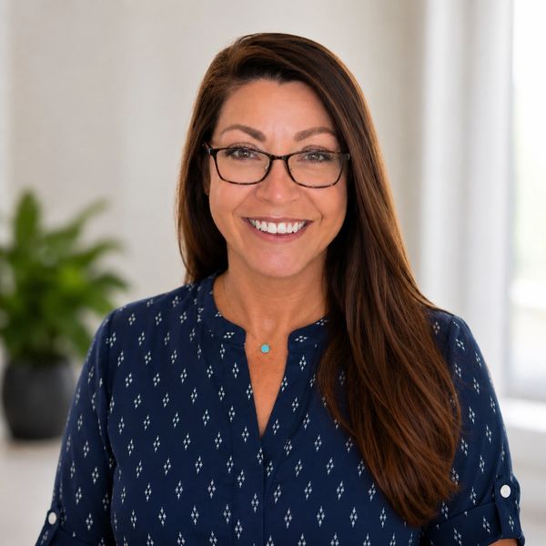 Smiling woman with glasses and long hair.