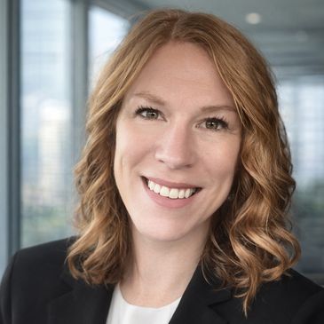 Professional woman with red hair smiling in an office setting.
