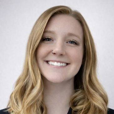 Smiling young woman with blonde hair and a nose ring.