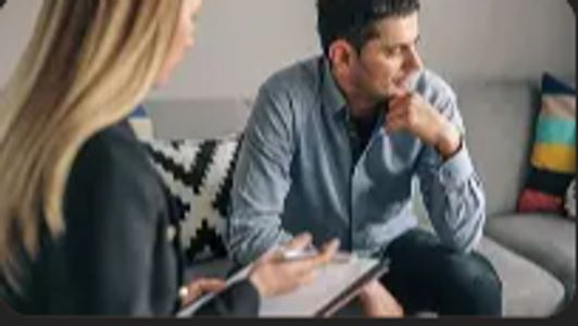 A man appears deep in thought during a counseling session.