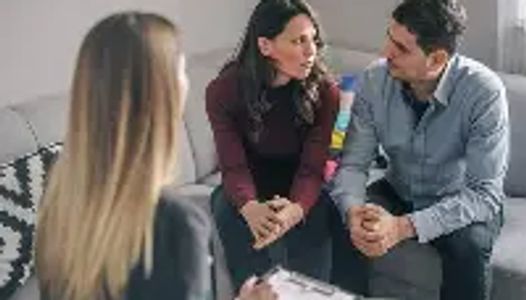 Couple discussing with a therapist in a counseling session.