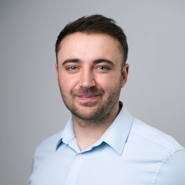 Smiling man in light blue shirt.