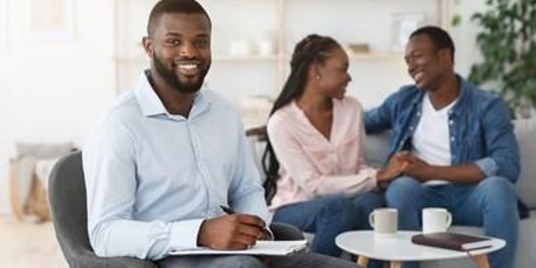 Therapist smiling with couple in counseling session.