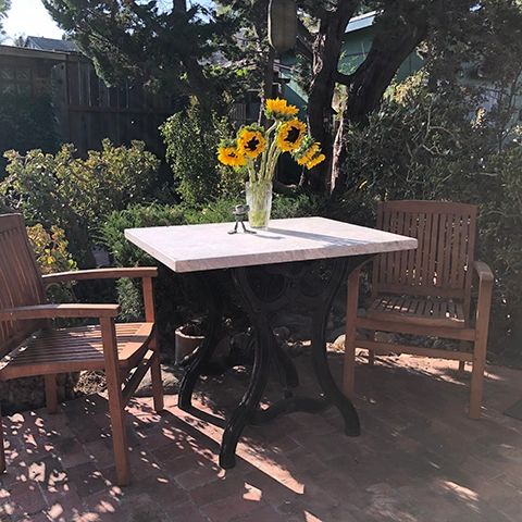 Outdoor table made from 1880s paper cutter base and marble slab.