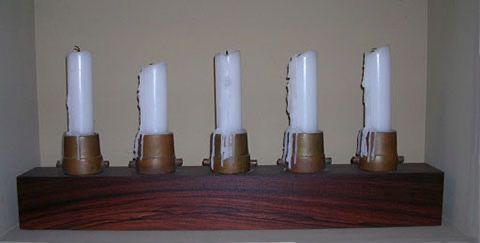 Candlestick holder made from brass fire hose nozzles on a padauk wood base by artist Tal Avitzur.
