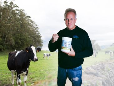 Dr Michael Lange holding up Fortifeye Super Protein next to grass fed cow best protein supplement 