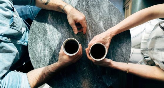 A man and woman talking over coffee.
